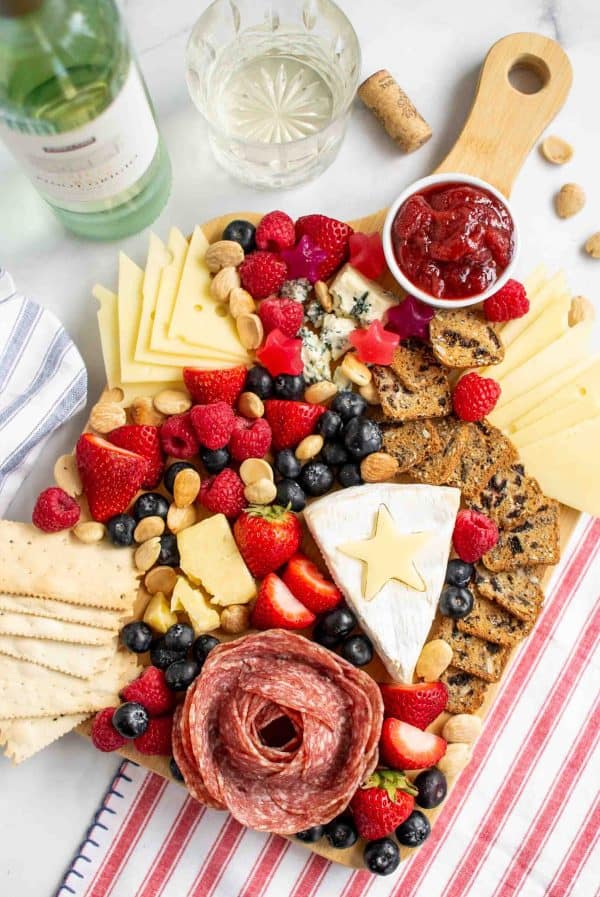 a mix of nuts, berries, cheese, a salami rose, and more gives this 4th of july charcuterie board ideas from get on plate a delicious vibe. 