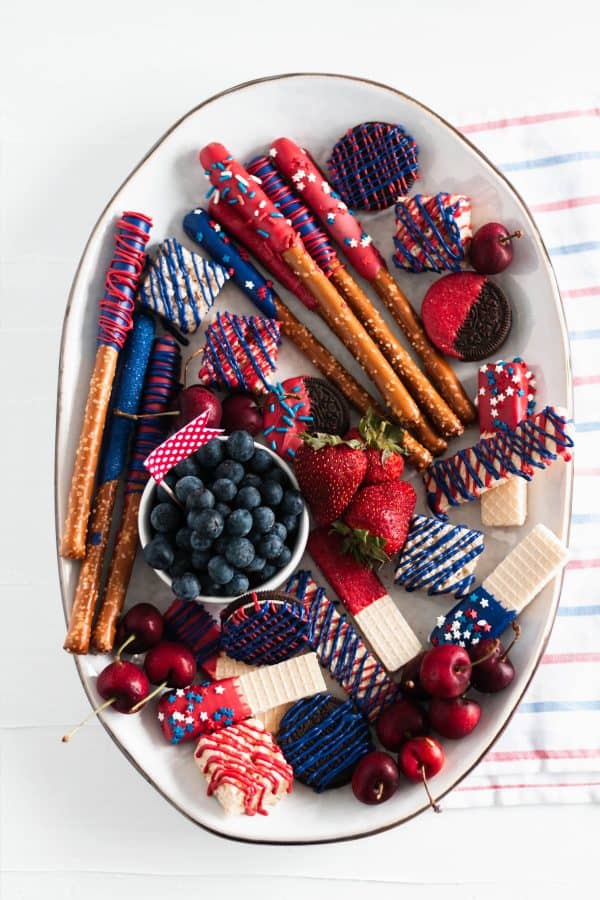 a simple and small dessert board with chocolate dipped pretzels, cookies, rice treats, and fruit from meg's everyday indulgence.