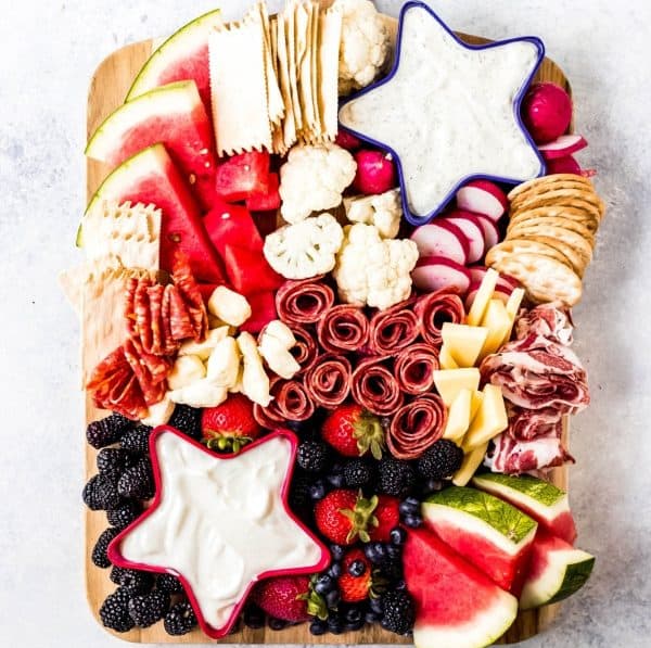 wanderlust and wellness includes red and blue star blues with dips along with crackers, fruit, meat, and cheese.