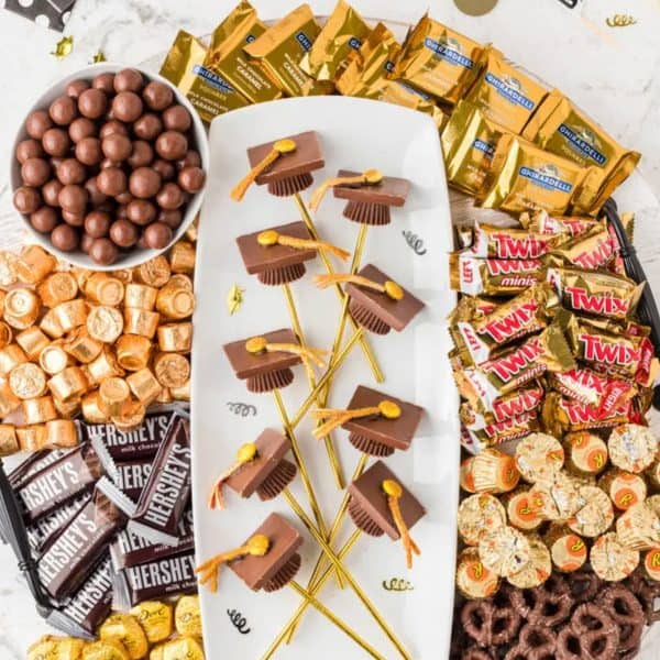 A candy board with candy graduation hats from The Denver Housewife.