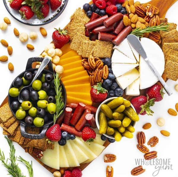 wholesome yum has a keto charcuterie board idea with olives, crackers, fruit, and cheese