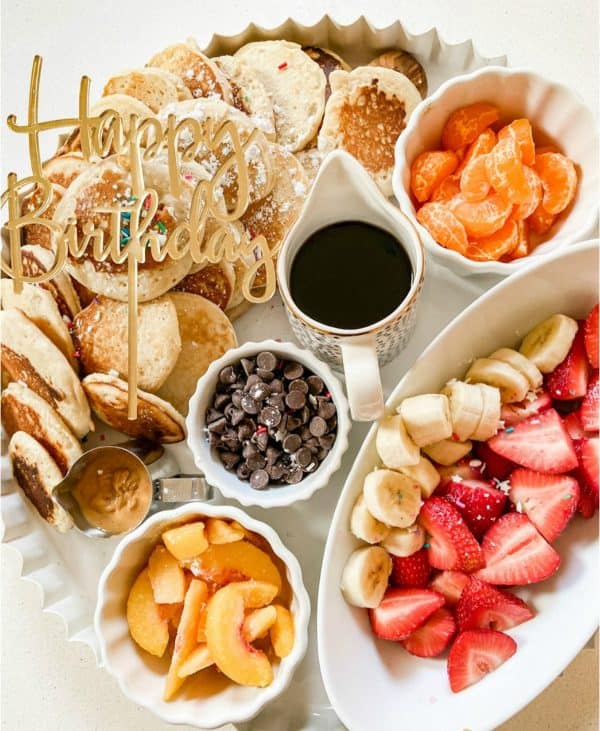 a happy birthday pancake board complete with fruit and sprinkles from tatertots and jello.