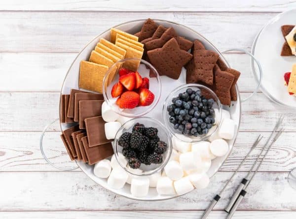 a simple s'mores charcuterie board recipe with chocolate graham cracker starts, chocolate, marshmallows, and berries from Arina Photography