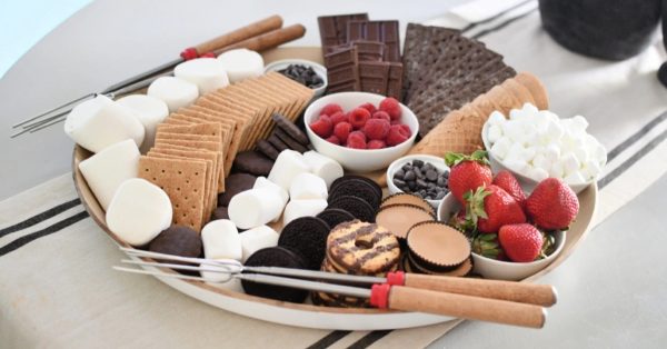 Hip2Save has a easy to grab board with all the fixing for a s'more with chocolate graham crackers, peanut butter cups, and marshmallows