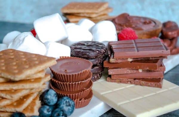 a pile of graham crackers, chocolate, cookies, and marshmallows to make a s/more charcuterie board from Marathons & Motivation. 