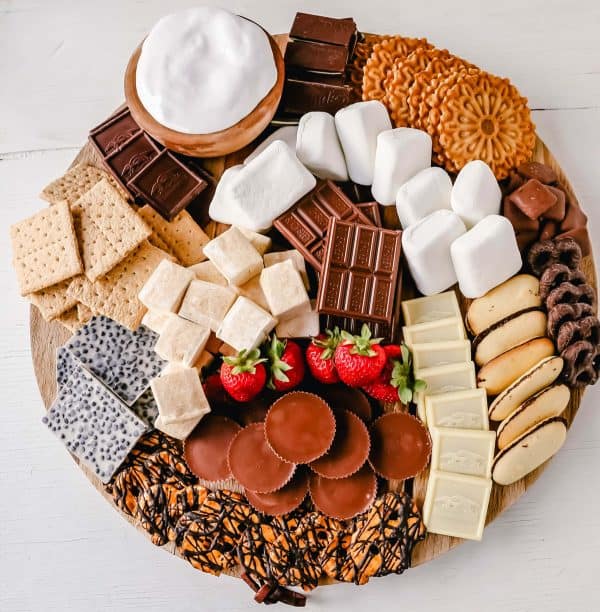Modern honey s'mores charcuterie board with marshmallows, chocolate, and other great treats.