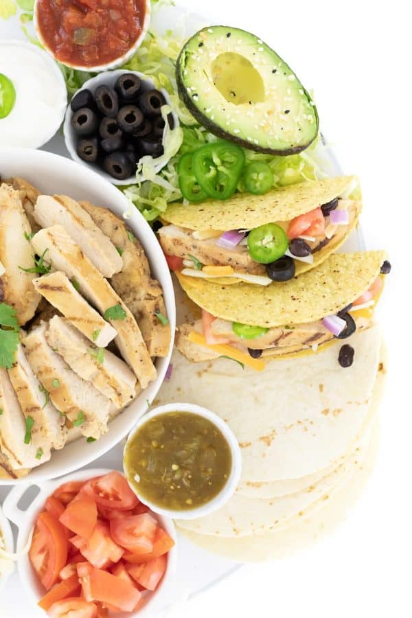 Mini tacos, avocado, olives, grilled chicken, and more make up this delicious board from Cutefetti.