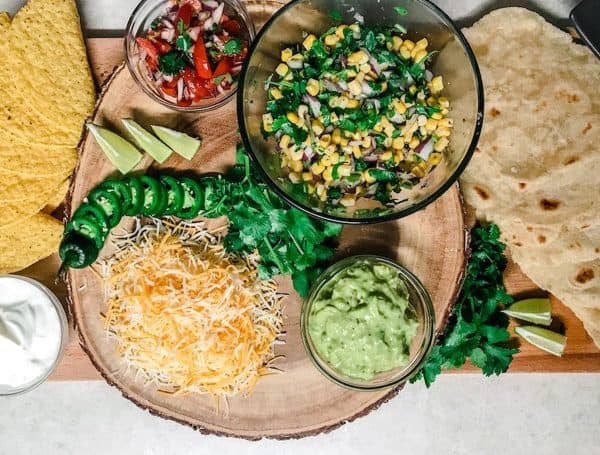 A large bowl of corn salsa, cheese, guacamole, and shells for the perfect taco from Hannah HQ. 