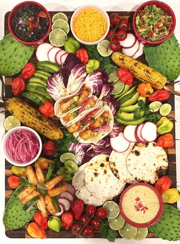 shrimp tacos, grilled corn, dips, and other veggies make this board from Herb your enthusiasm delicious.
