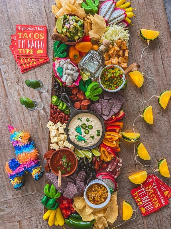 A large, colorful taco charcuterie board with dragon fruit, peppers, multiple dips, and chips from life by leanna.