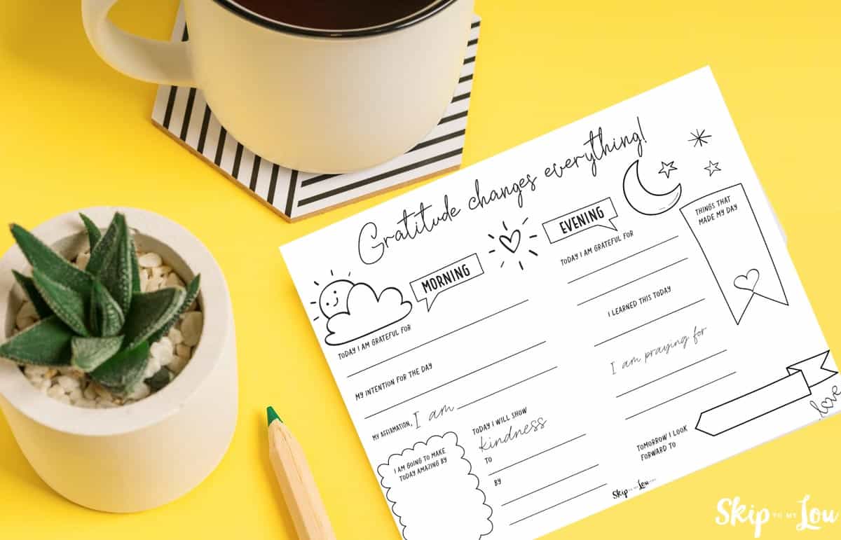 gratitude journal template next to a cup of coffee and a potted plant.