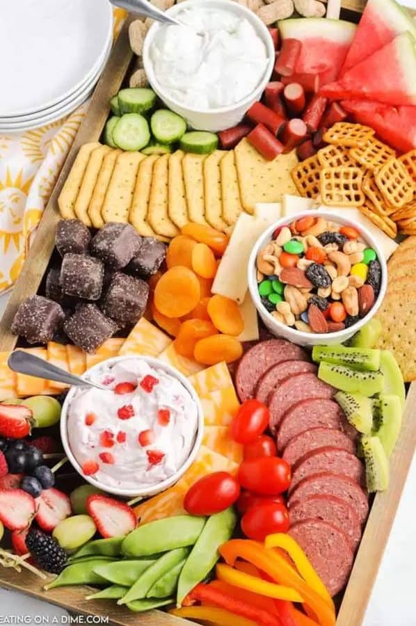 kid friendly charcuterie board with meats, veggies, fruit, trail mix, and even some candies from eating on a dime.