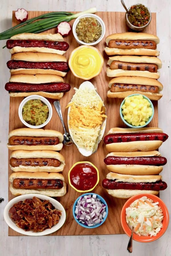 hot dogs in a line with different condiment choices like mustard, ketchup, etc from miss in the kitchen
