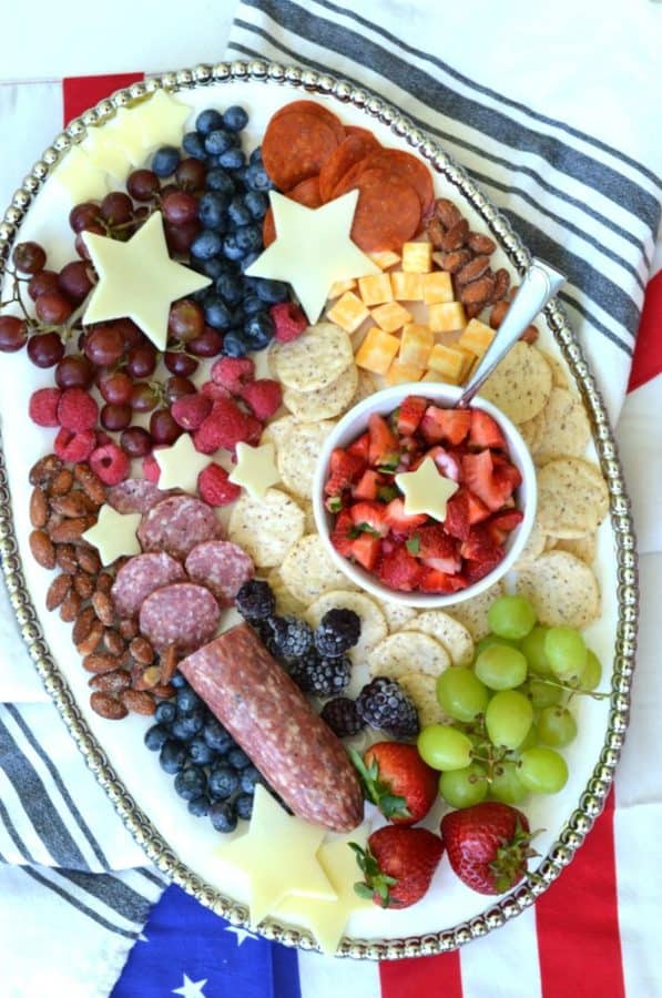 A board with grapes, strawberries, cheese stars, and more.