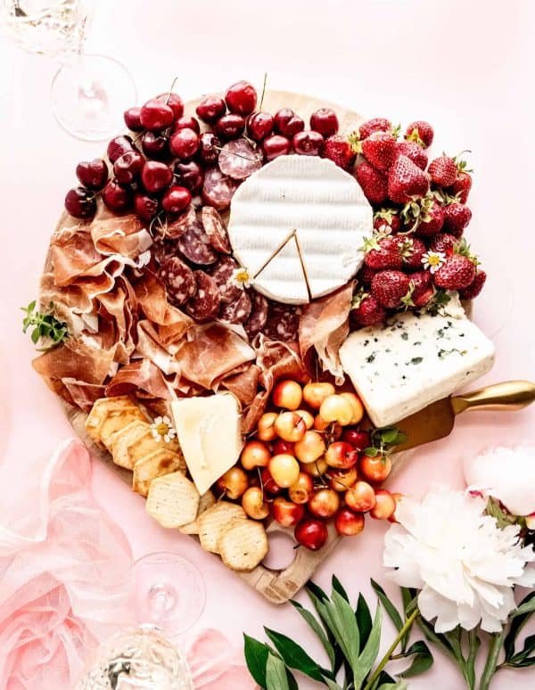 a red board with raspberries, cherries, and some brie cheese from windy city dinner fairy