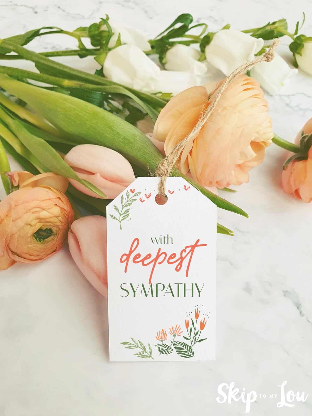 Image shows a flower bouquet with a sympathy tag tied to it. Skip to my Lou.