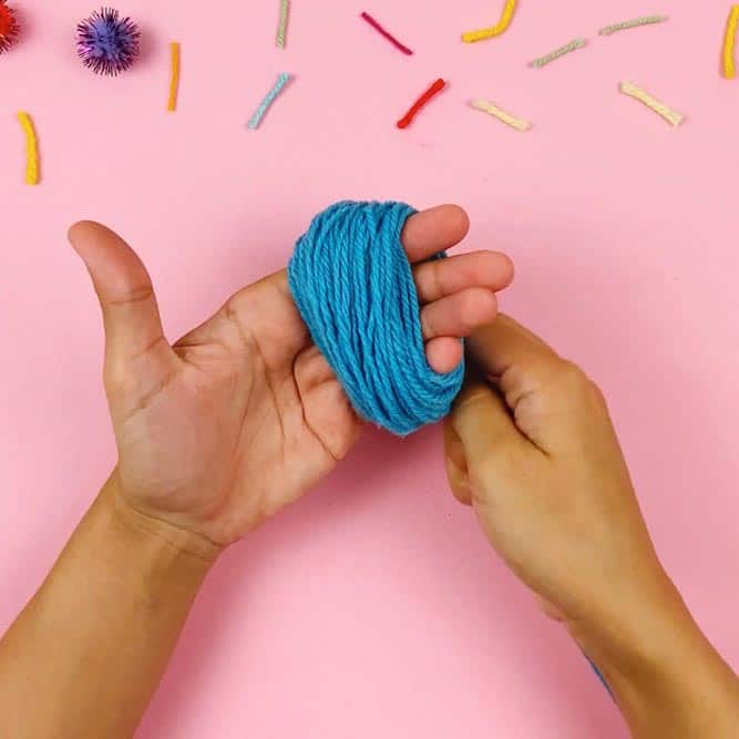 wrap yarn around hand for pom pom