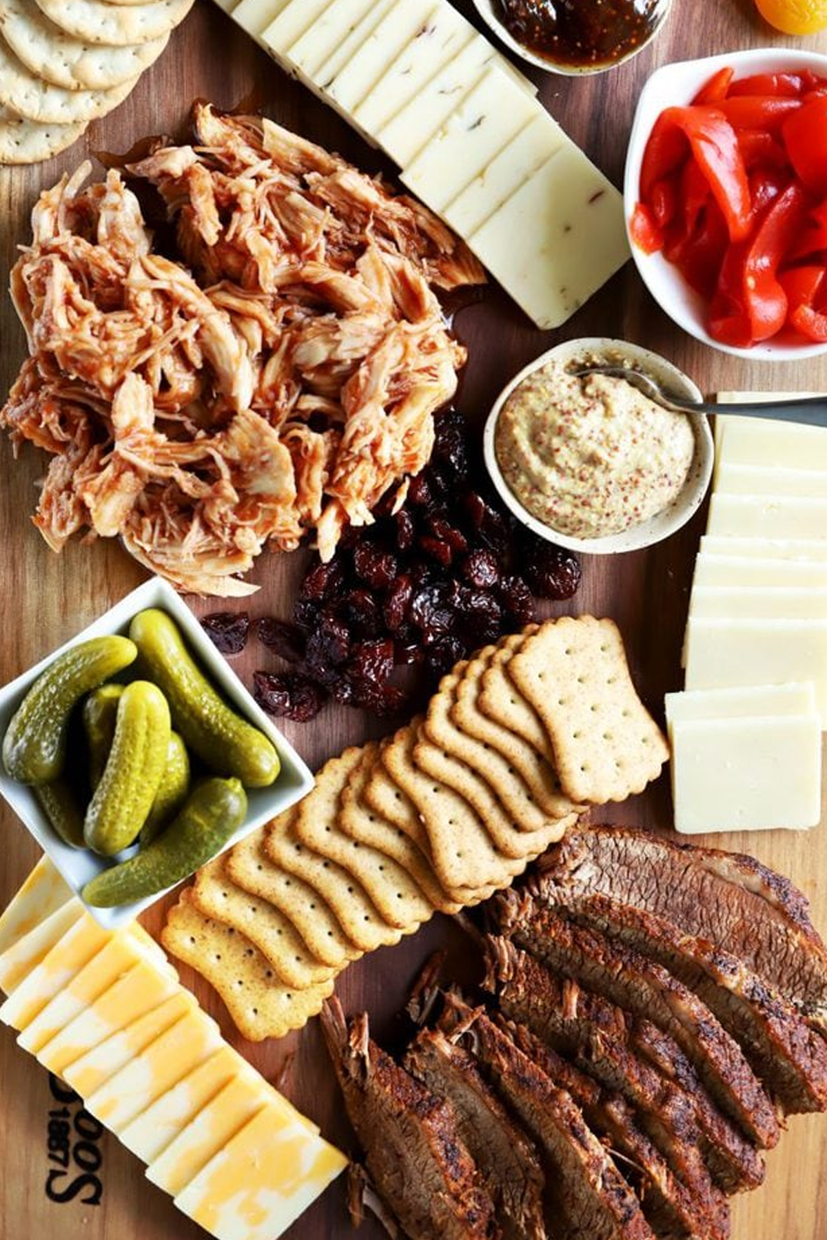 Cake 'n Knife pulled chicken, steak, cheese, peppers, and crackers on their bbq charcuterie wooden board.