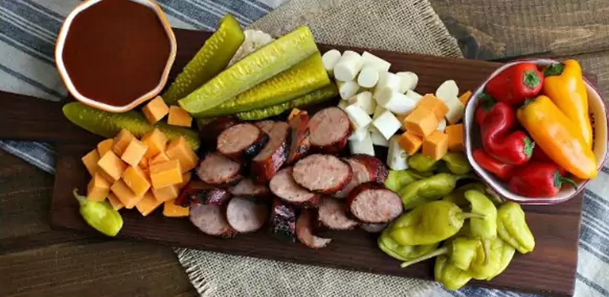 simple board with pickles, peppers, sausage, and bbq sauce create this board from homemade interest.