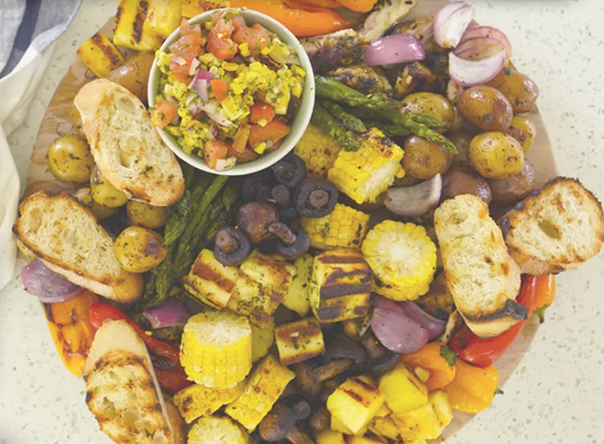 Parade icnludes a grilled bbq charcuterie board with corn, bread, potatoes, and more.
