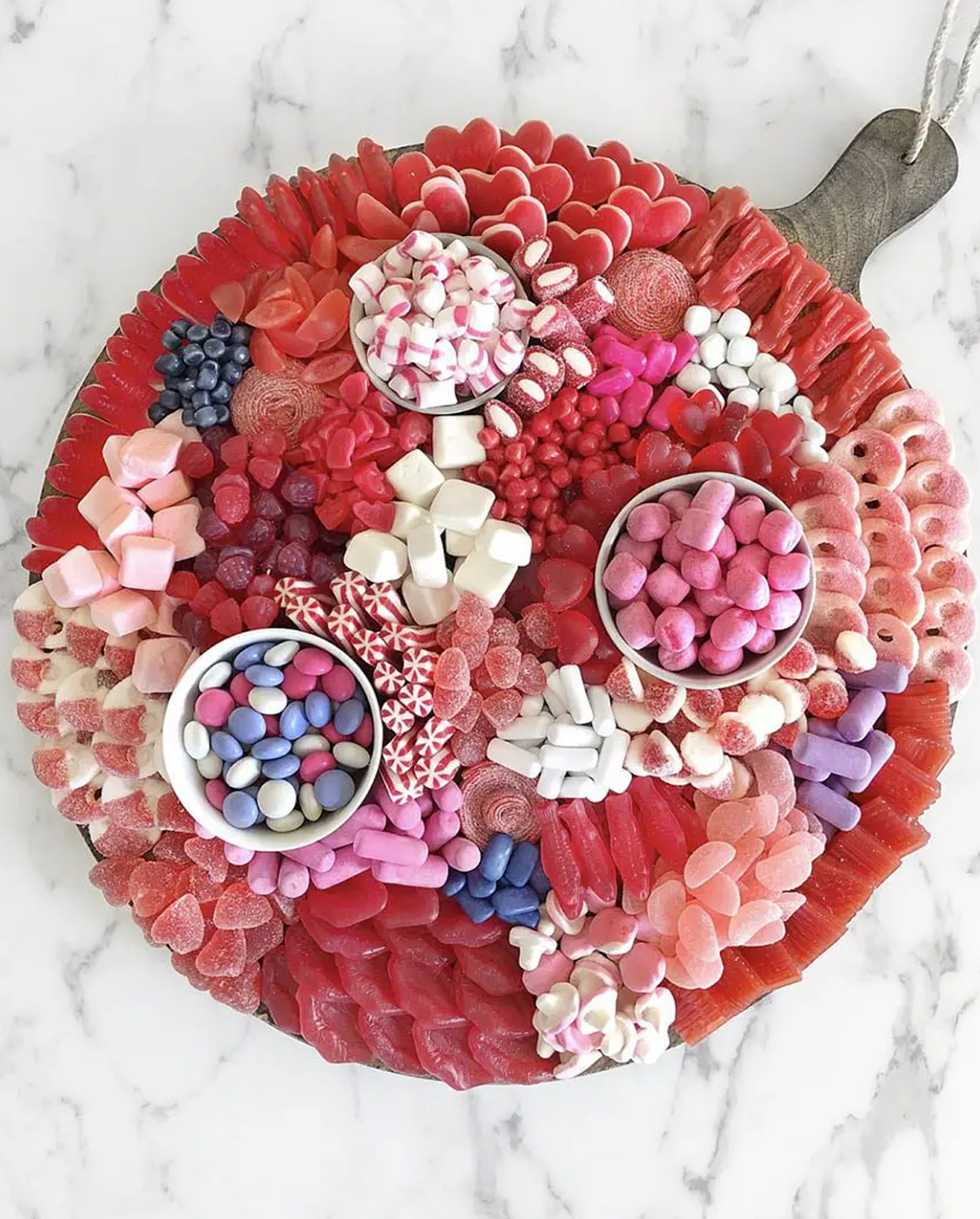 If your guests have a sweet tooth then this baby shower charcuterie board idea from Ain't Too Proud To Meg is perfect with pink, red, purple, and white candies.