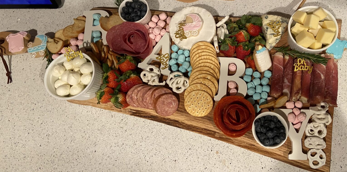 A simple charcuterie board spread from Just Jennier Renee with decoration for baby showers.