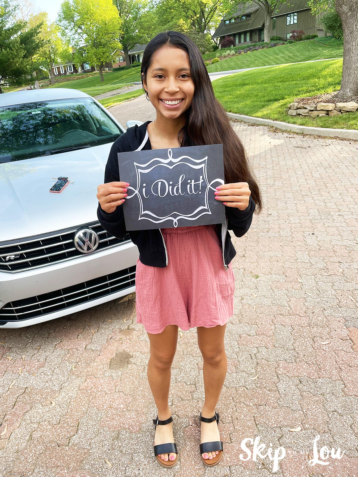 girl holding i did it sign to mark the last day of school