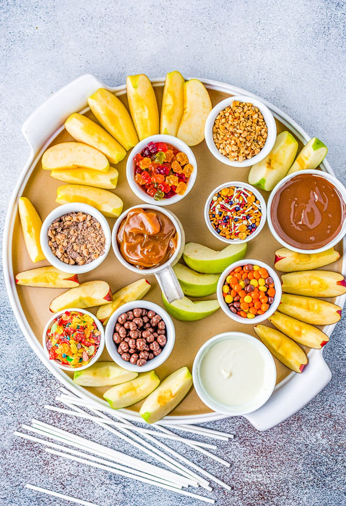 Averie Cooks' fall caramel apple charcuterie board is full of Honeycrisp Apples, Oreos, Reeces peanut butter cups, caramel sauce, sprinkles, nuts, and gummy bears.