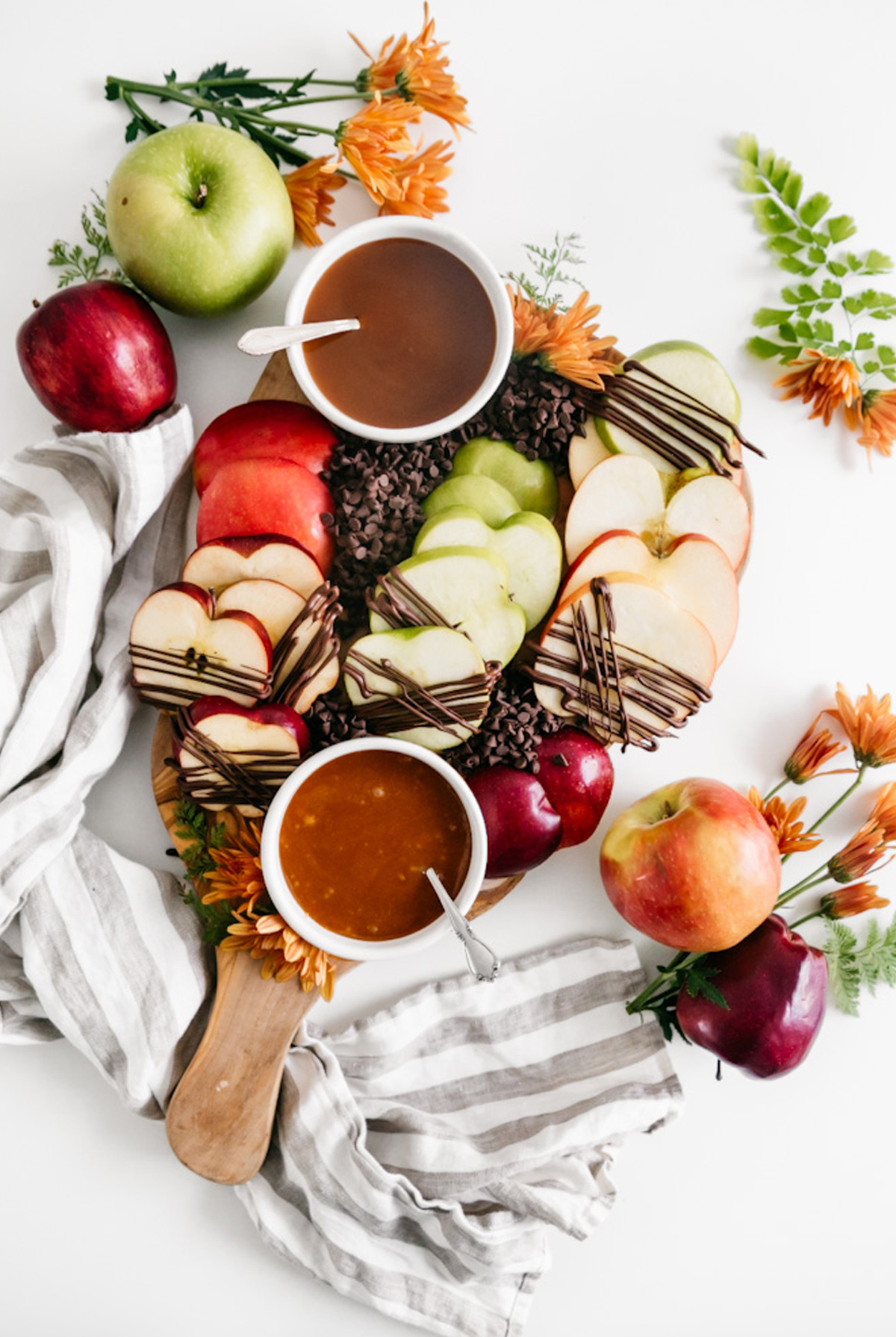 Heather's Home Bakery's Caramel Dessert board showcases slices of apples, melted chocolate, and chocolate chips.