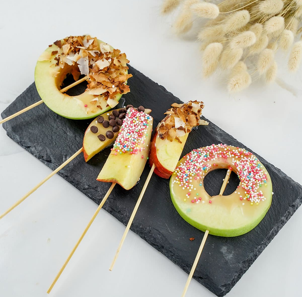 Caramel Apple Slices covered with caramel, sprinkles, and chocolate chips fills No Bake Recipes Caramel Apple Fall Board.