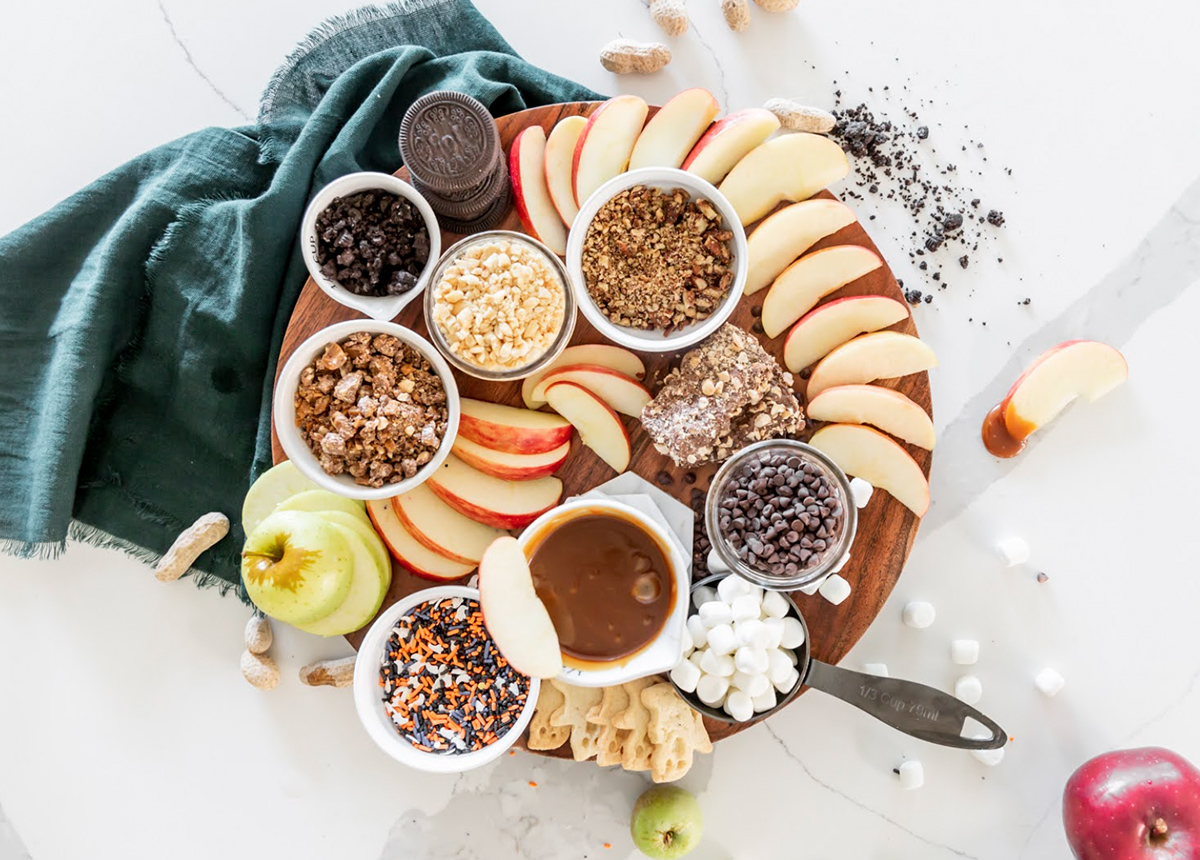 Apples, caramel sauce, sprinkles, Oreos, chocolate chips, and marshmallows fills Salt Harvest Creatives' caramel apple charcuterie board.