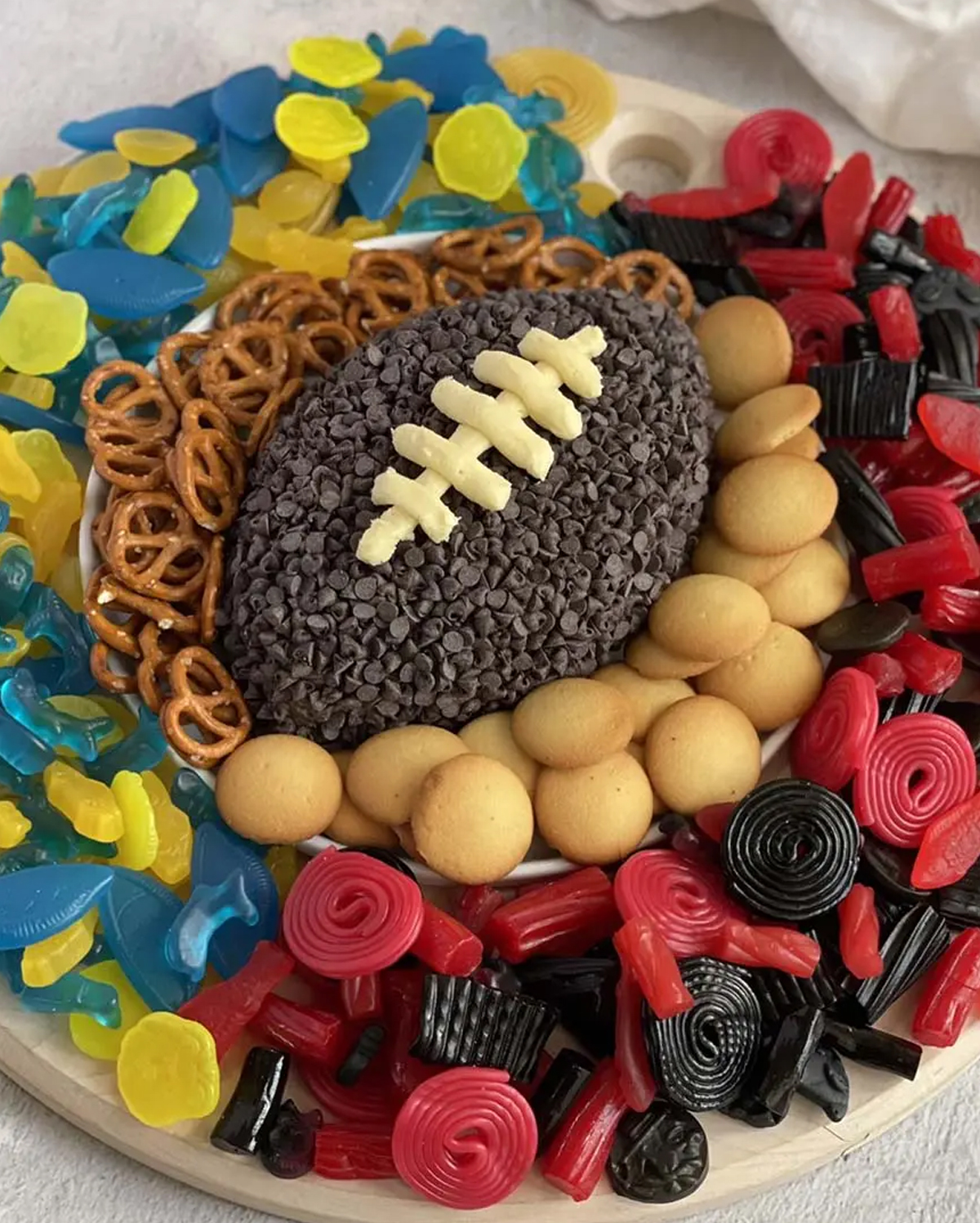 Ain't Too Proud to Meg creates a football dessert board full of gummies, pretzels, cookies and a chocolate chip football.