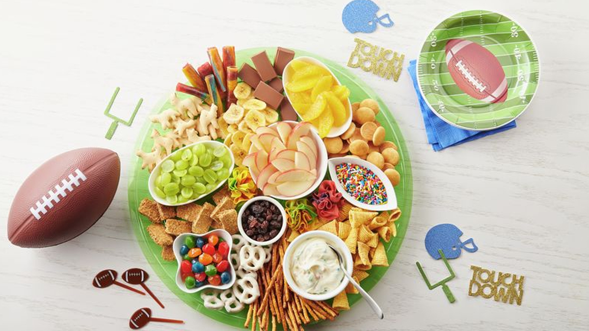 Betty Crocker showcases pretzel sticks, bugles, apple slices, grapes, cookies, and fruit roll-ups on this football themed charcuterie board.