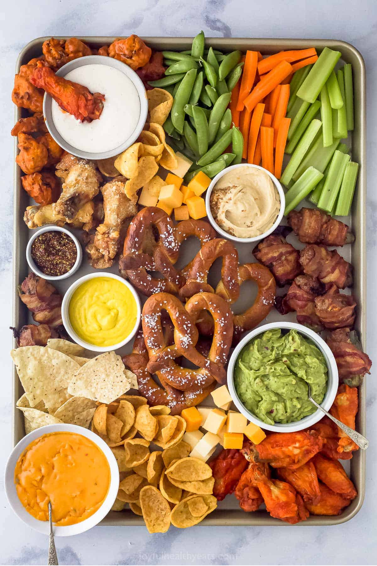 Wings, dips, carrots, celery, and cheese are displayed on Joyful Healthy Eats football charcuterie board,