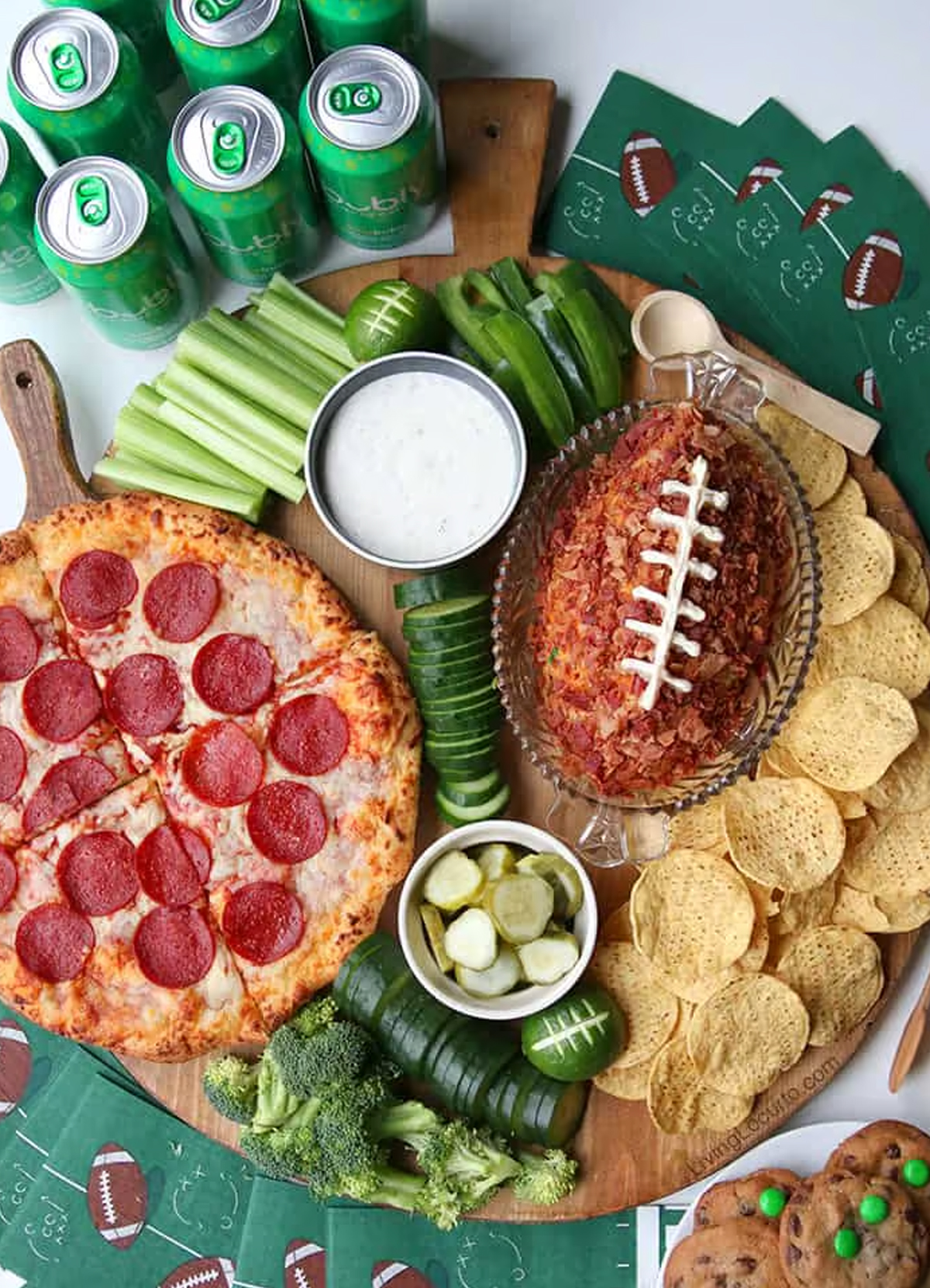 Living Locurto's board showcases pepperoni pizza, cucumbers, bell peppers, corn chips, and a football cheese ball.