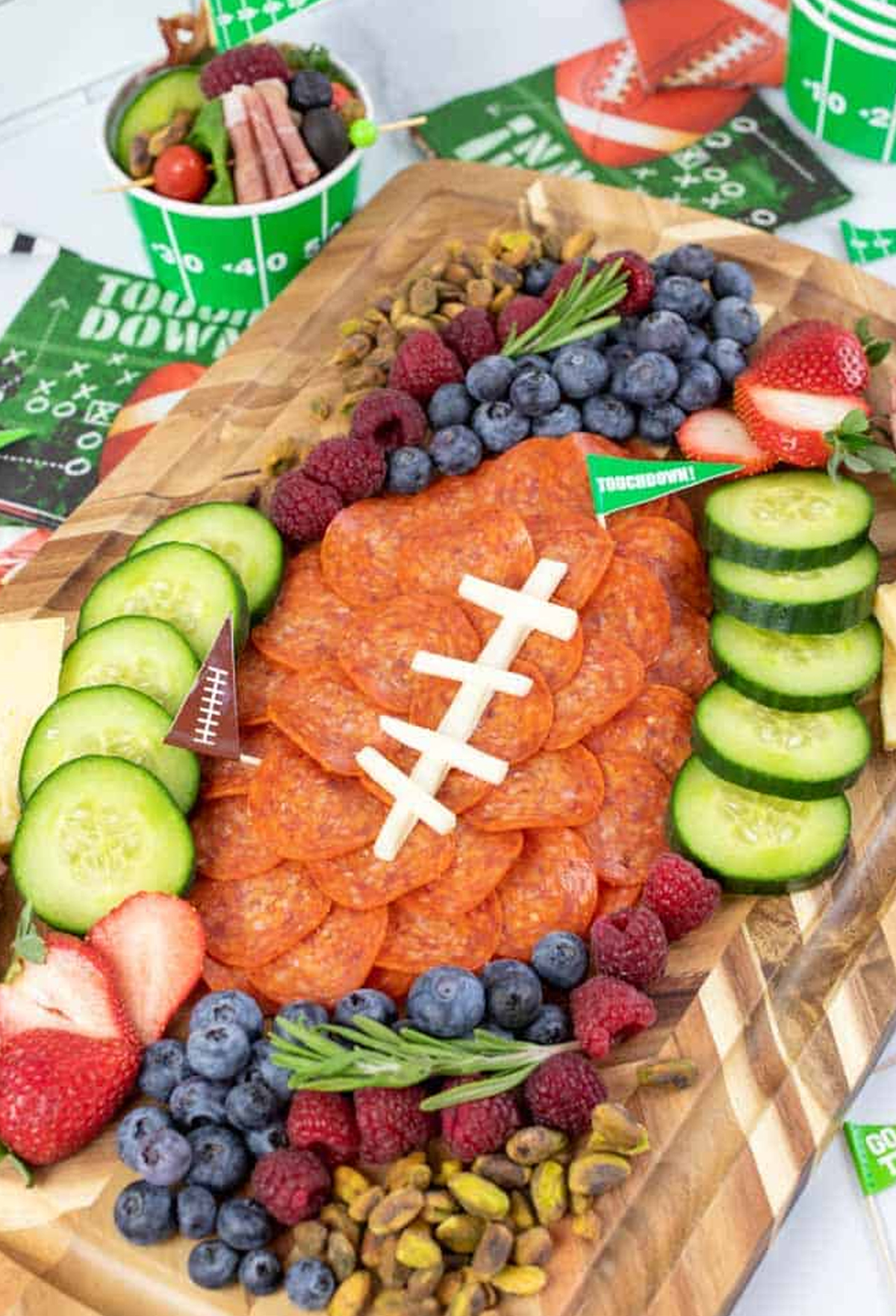 Low Carb Inspirations includes a pepperoni football, blueberries, raspberries, and cucumbers on their football charcuterie board.