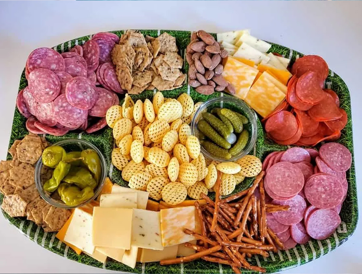 Moore or Less Cooking includes a football themed board full of pepperoni, cheese, salami meat, pretzels, and crackers.