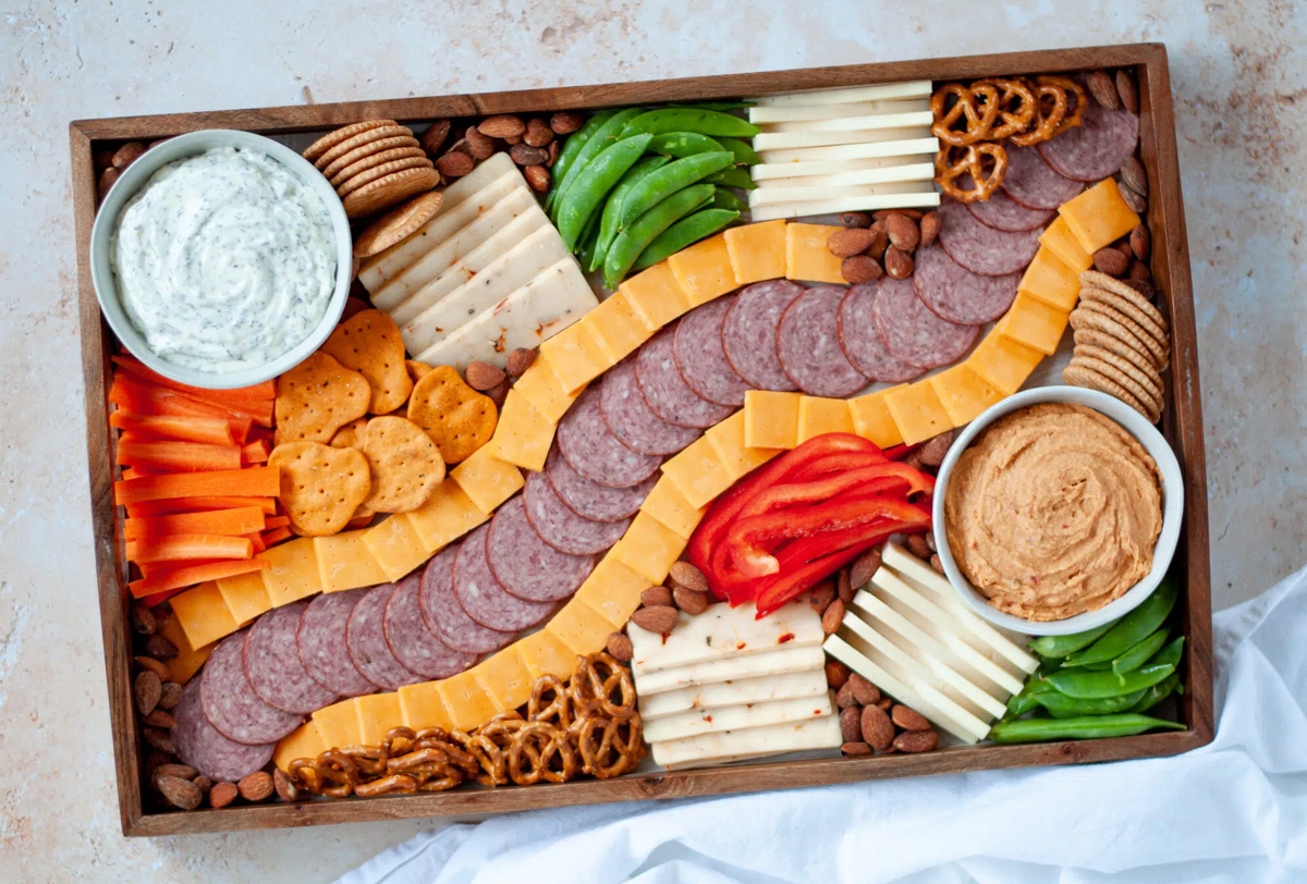 Our Love Language is Food included meat, cheese, veggies, pretzels, and nuts on their football charcuterie board.
