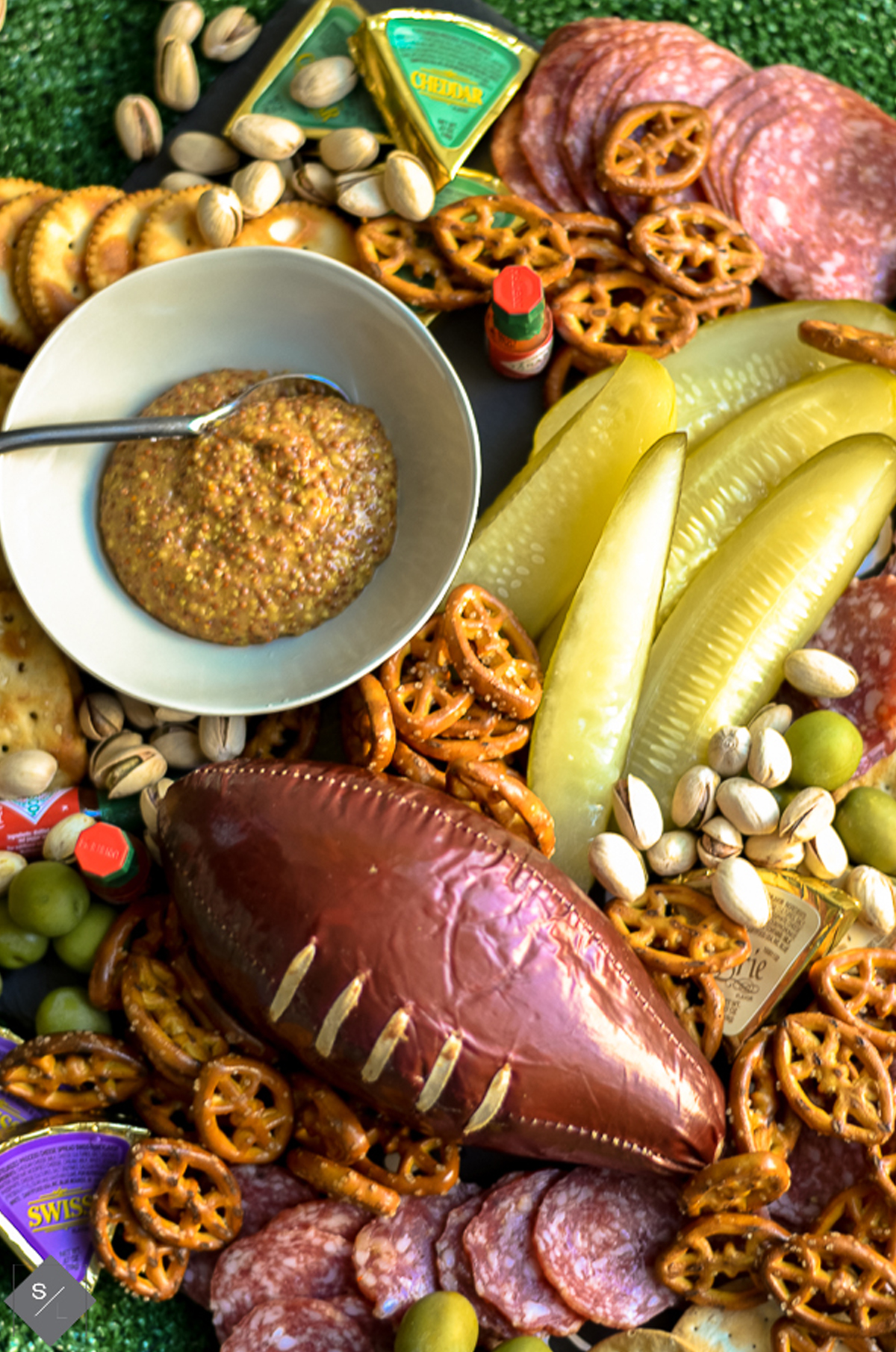Pickles, crackers, meat, cheese, pretzels, and football sausage fill See Lindsay's game day board.