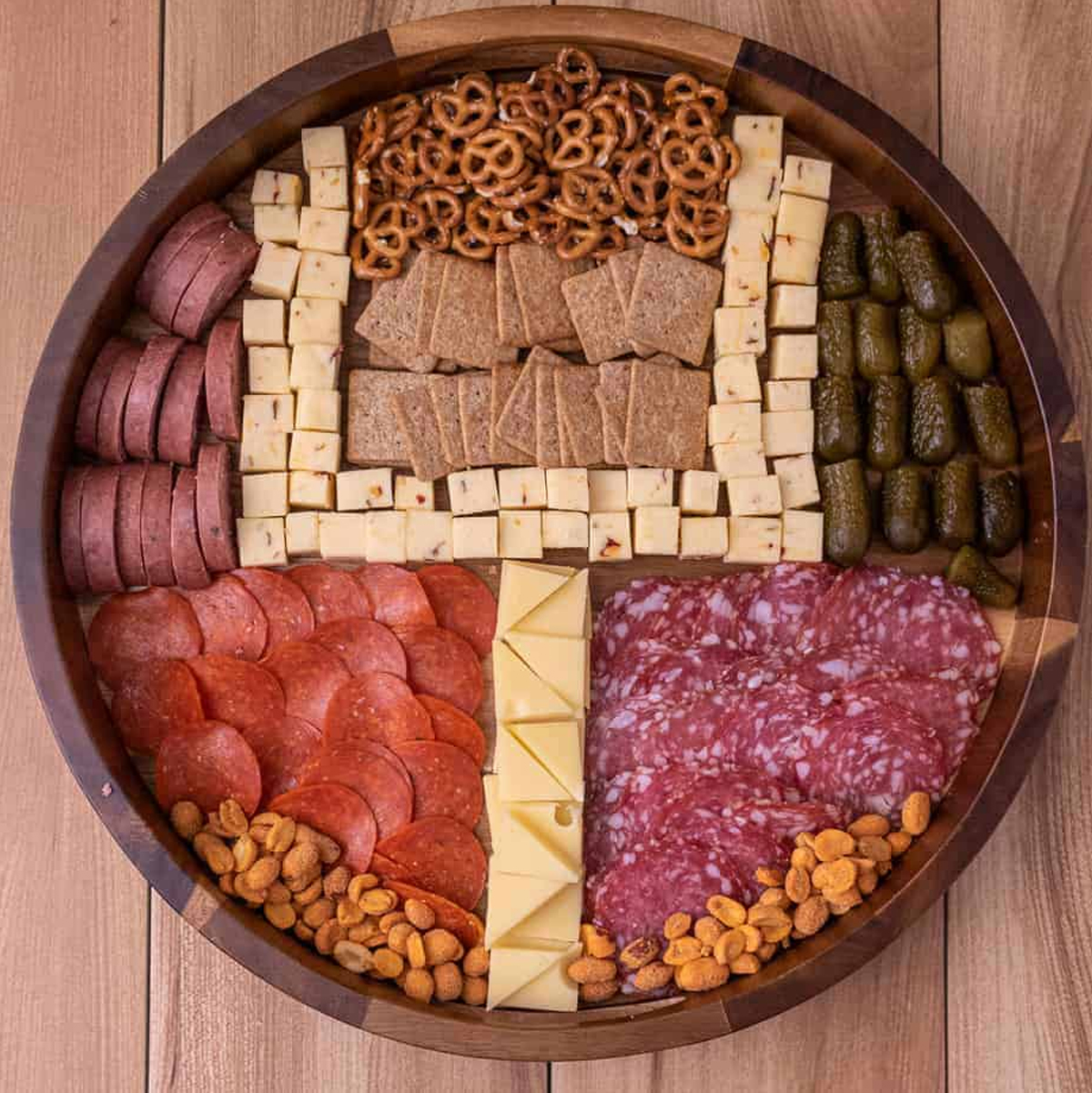 Smack of Flavor's football charcuterie board includes pepperoni, cheese, crackers, pickles, and nuts.