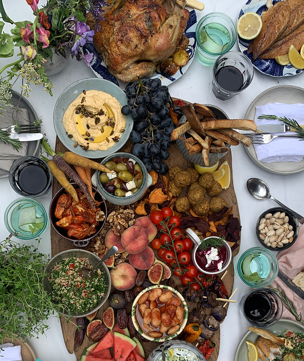 a large board with a variety of choices including hummus, vegetables, meatballs, and more from abel & cole