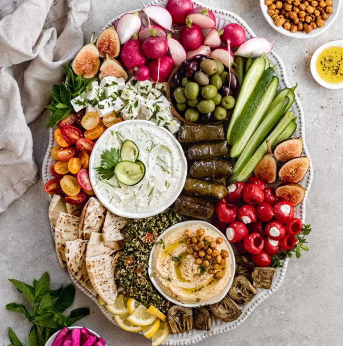figs, artichokes, stuffed peppers, and dips are all part of this delicious board from ain't too proud to meg.