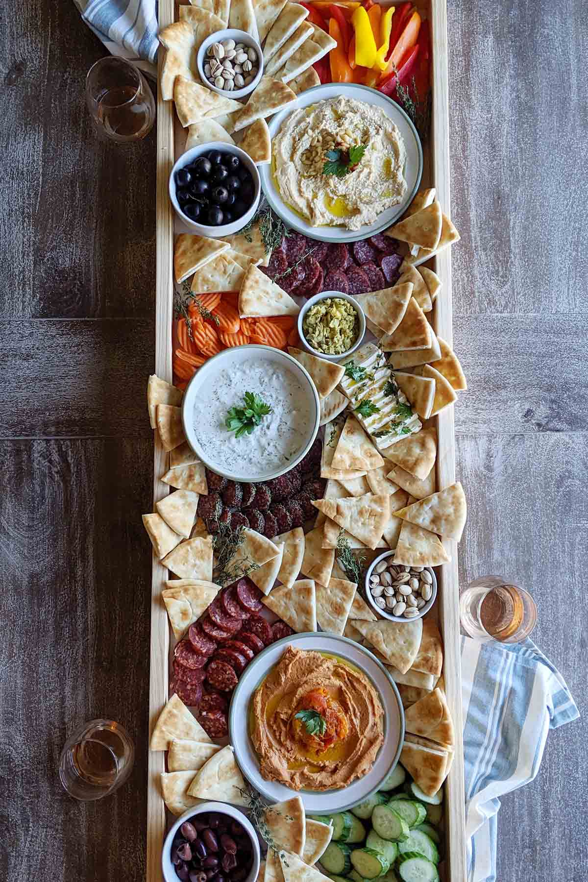 homebody eats includes hummus, pita chips, olives, and more on her greek charcuterie board.