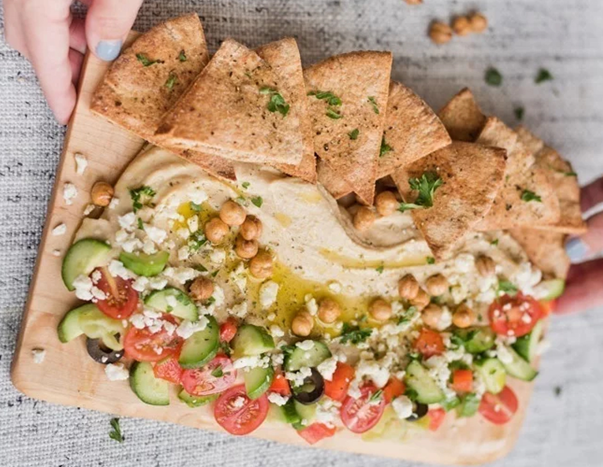 a simple date night board with hummus, feta, cucumbers, tomatoes, and more from lovely food blog.