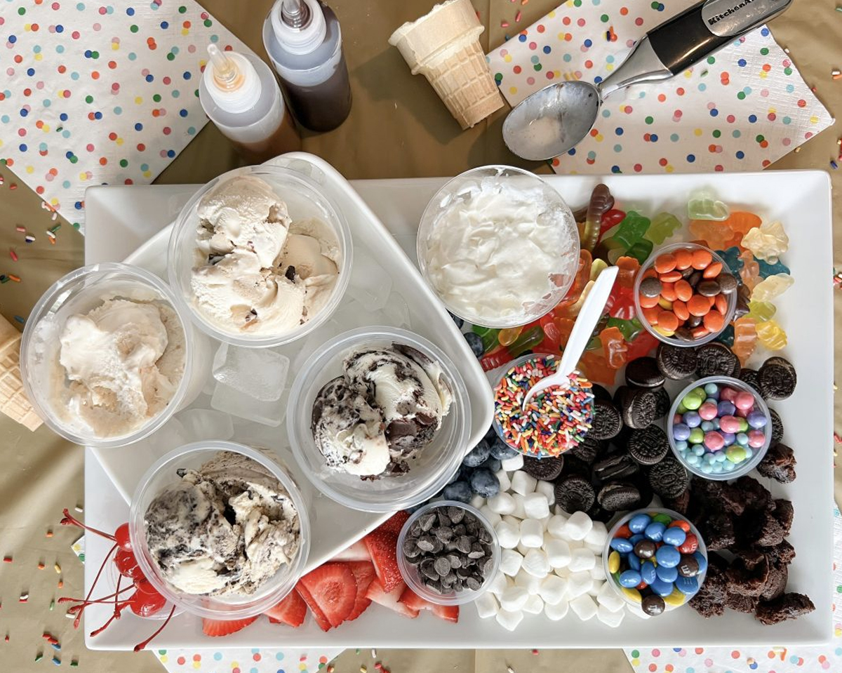 A pre scooped ice cream charcuterie board from Detroit Mom with toppings and ice cream already served in small bowls over ice