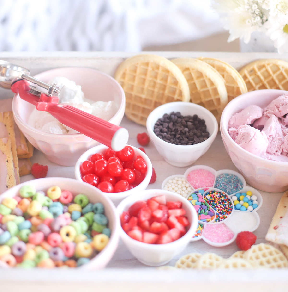 A whimsical ice cream board with cherries, mini chocolate chips, fruit loops and more from Glitter, Inc.