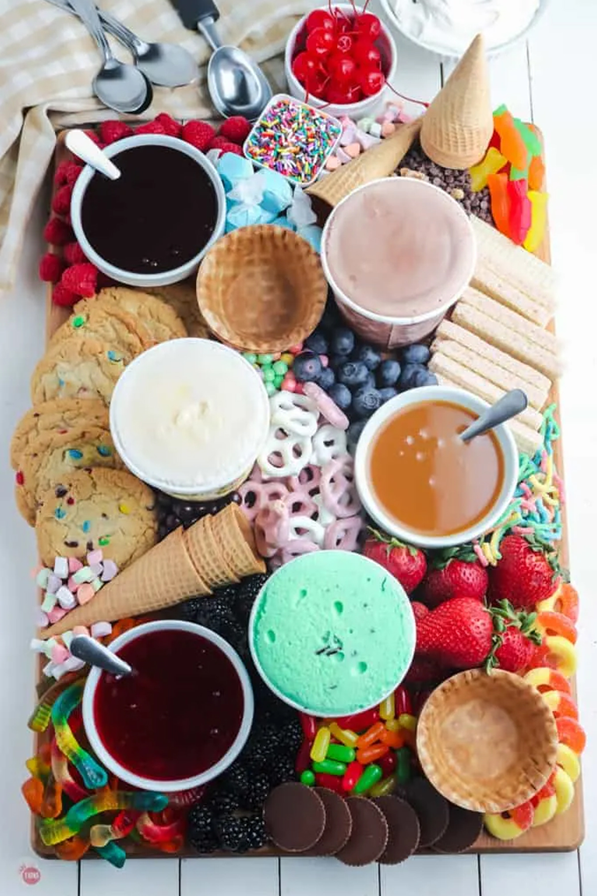 M&M cookies, yogurt pretzels, strawberries, gummy worms, and plenty of sauces cover this board from Take Two Tapas.