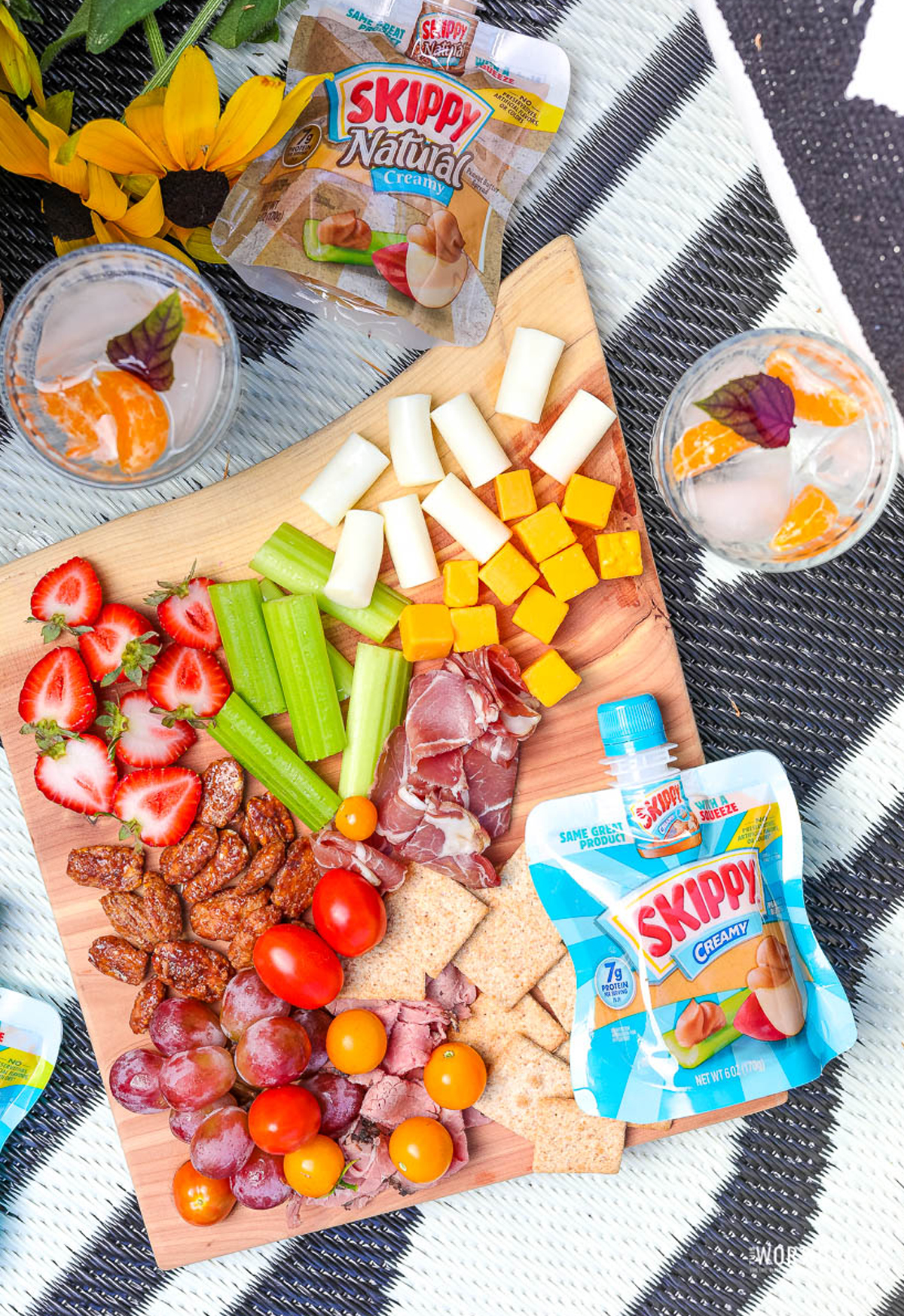 a kid friendly charcuterie board with peanut butter, cubed cheese, celery, strawberries, cheese sticks, and more from a worthey read.