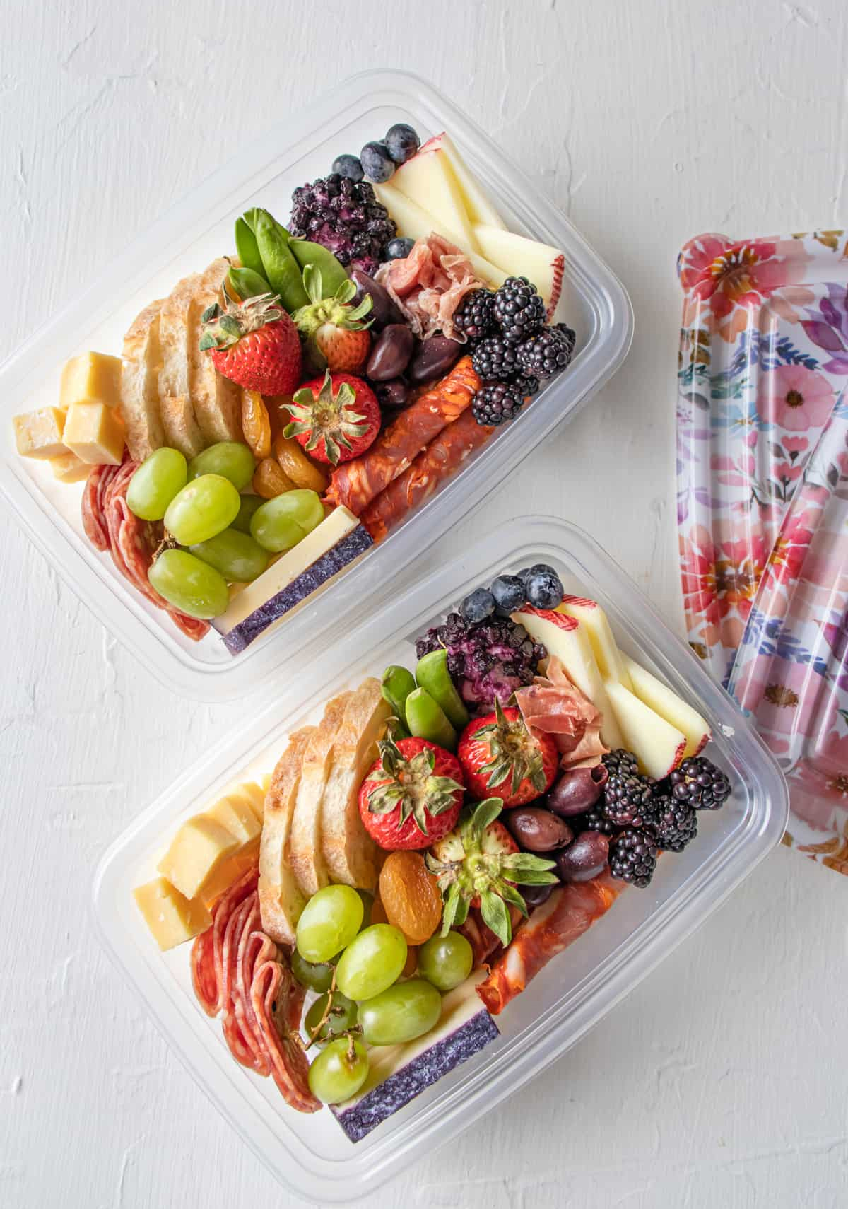 two to-go containers filled with cheese, fruit, and bread from fueling a southern soul.