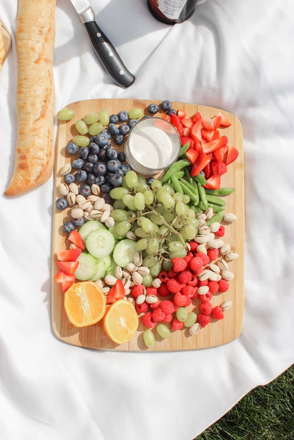 a fruit filled picnic charcuterie board with grapes, blueberries, strawberries and more from rachel's craftered life.